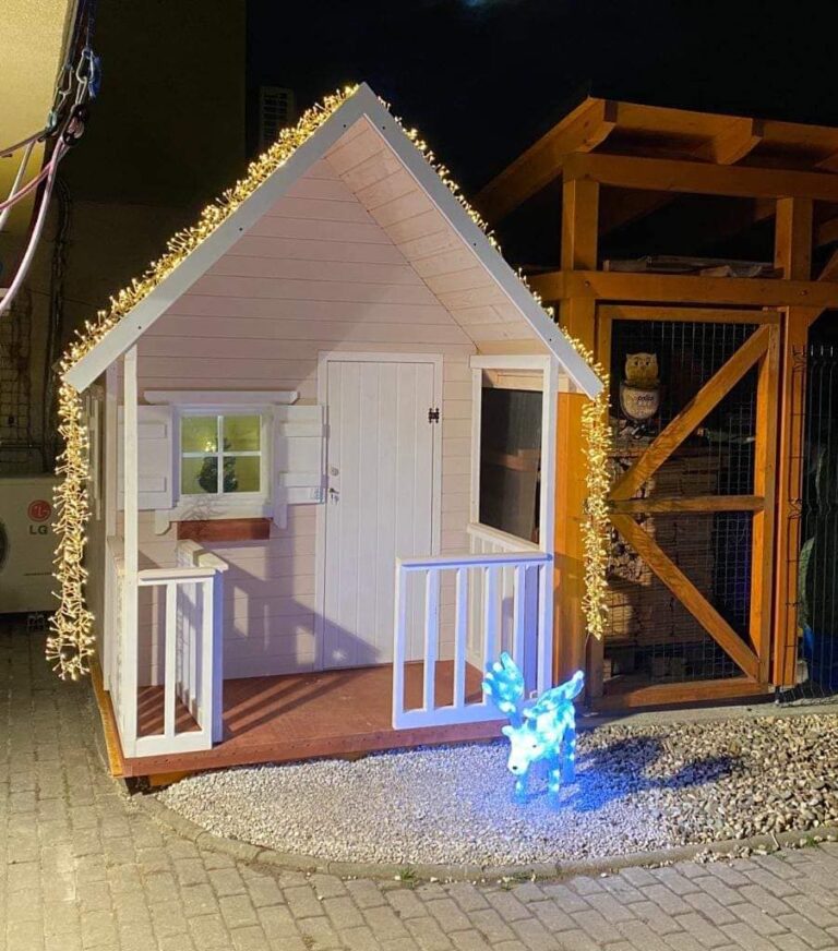 záhradný drevený domček ako vianočný darček vysvietený a ozdobený vianočnou výzdobou