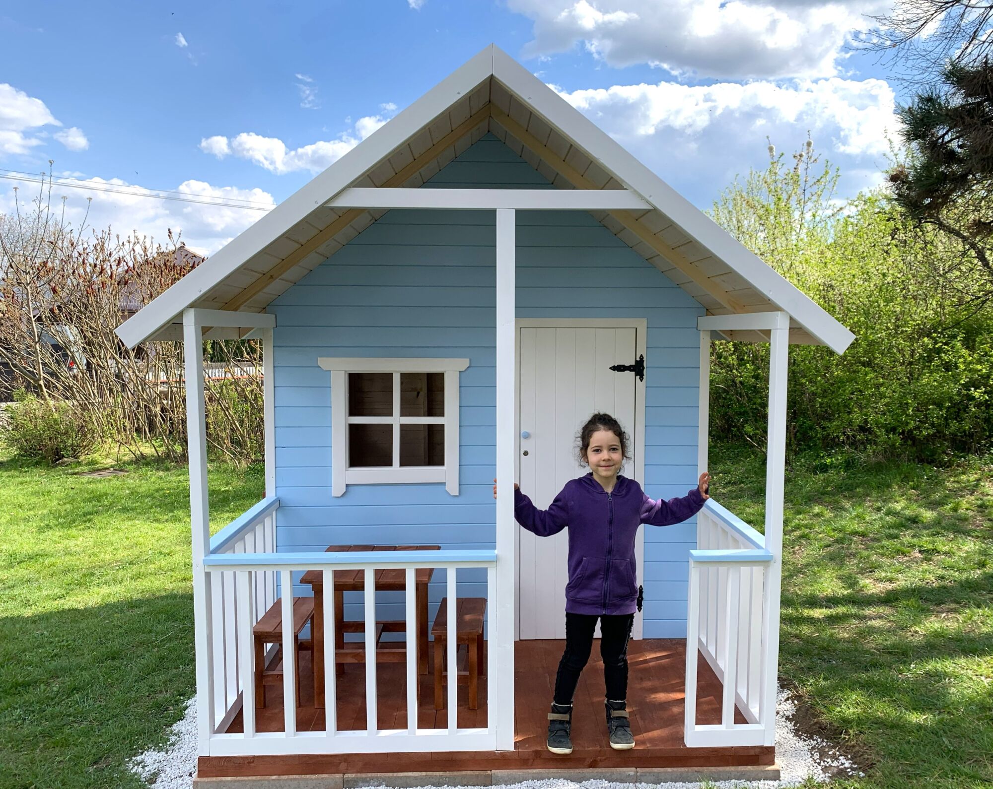dieťa sa teší z&nbsp;nového záhradného dreveného domčeka pre deti